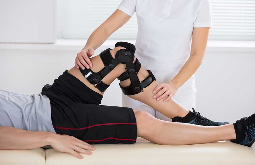 Therapist adjusting a knee brace on a patient