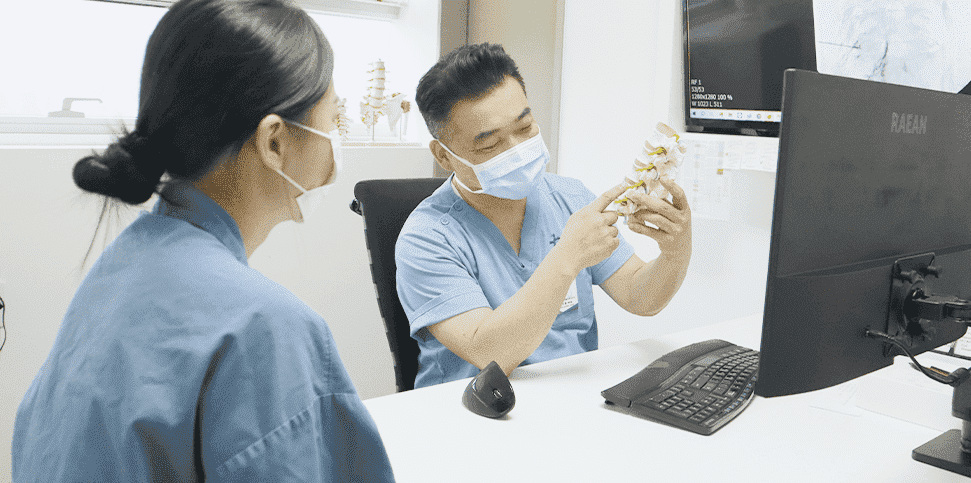 Doctor explaining a diagnosis with a spine model